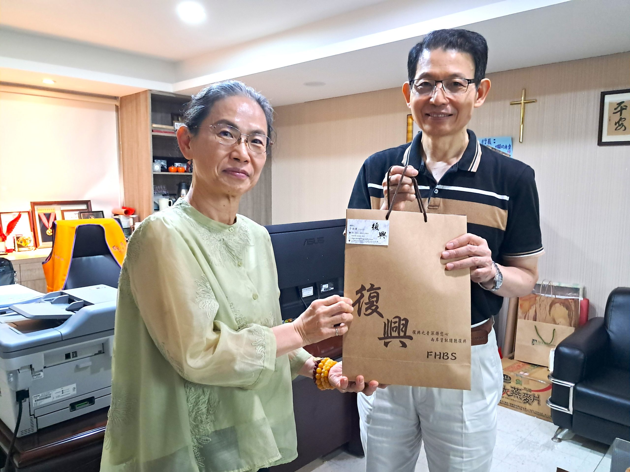 復興電台總台長李淑蕙女士致贈公關禮品予社團法人中華安得烈慈善協會執行長羅紹和先生。  (圖片來源：記者曾子傑攝)